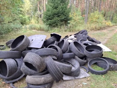 Kolejne dzikie wysypisko w lesie. Ktoś porzucił stertę opon i części samochodowych